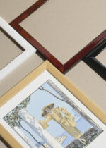 Zbliżenie na detale plakatu oprawionego w drewnianą białą ramkę od Plakatello®: Amalfi George Barbier art déco kobieta vintage