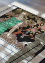 Widok z góry na cztery drewniane ramki, w jednej z nich oprawiony plakat Art Deco George Barbier La Première Imprudence