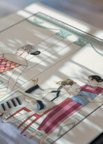 Widok z góry na cztery drewniane ramki, w jednej z nich oprawiony plakat La Toilette Délicieuse George Barbier Art Deco 1921