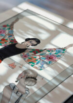 Widok z góry na cztery drewniane ramki, w jednej z nich oprawiony plakat Art Deco George Barbier kobieta w szacie nad morzem