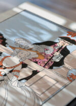 Widok z góry na cztery drewniane ramki, w jednej z nich oprawiony plakat humorystyczny La Leçon bien apprise George Barbier Art Deco