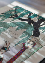 Widok z góry na cztery drewniane ramki, w jednej z nich oprawiony plakat L'amant Poète Et ego in Arcadia George Barbier art déco