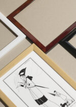 Zbliżenie na detale plakatu oprawionego w drewnianą białą ramkę od Plakatello®: czarno-biały Art Deco kobieta w deszczu George Barbier 1914