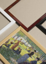 Widok z góry na cztery drewniane ramki, w jednej z nich oprawiony plakat Georges Seurat pointylizm wiejski krajobraz vintage