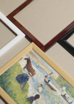 Widok z góry na cztery drewniane ramki, w jednej z nich oprawiony plakat Georges Seurat scena nad rzeką pointylizm XIX w. koń łódki