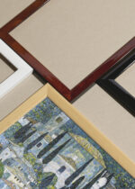 Widok z góry na cztery drewniane ramki, w jednej z nich oprawiony plakat Kościół w Cassone Gustav Klimt 1913 jezioro Garda we Włoszech