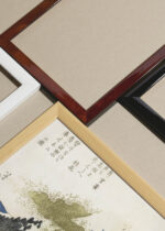 Widok z góry na cztery drewniane ramki, w jednej z nich oprawiony plakat Góra Fuji z jeziora Ashi spowita chmurami Katsushika Hokusai