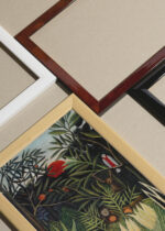 Widok z góry na cztery drewniane ramki, w jednej z nich oprawiony plakat Tropikalna dżungla Henri Rousseau reprodukcja