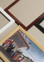 Widok z góry na cztery drewniane ramki, w jednej z nich oprawiony plakat Przedstawiciele ludów Henri Rousseau naiwizm reprint