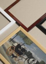 Widok z góry na cztery drewniane ramki, w jednej z nich oprawiony plakat kariolka La Carriole du Père Junier Henri Rousseau