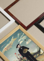 Widok z góry na cztery drewniane ramki, w jednej z nich oprawiony plakat Henri Rousseau Ja: Portret-Pejzaż 1890