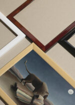 Widok z góry na cztery drewniane ramki, w jednej z nich oprawiony plakat Śpiąca cyganka La Bohémienne endormie Henri Rousseau