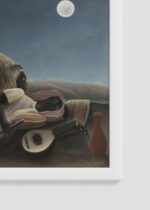 Zbliżenie na detale plakatu oprawionego w drewnianą białą ramkę od Plakatello®: Śpiąca cyganka La Bohémienne endormie Henri Rousseau