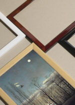 Widok z góry na cztery drewniane ramki, w jednej z nich oprawiony plakat Henri Rousseau Karnawał wieczorem naiwne malarstwo