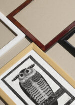 Widok z góry na cztery drewniane ramki, w jednej z nich oprawiony plakat sowa drzeworyt Samuel Jessurun de Mesquita vintage