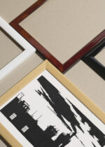 Widok z góry na cztery drewniane ramki, w jednej z nich oprawiony plakat czarno-biały  industrialny Elektrownia gazowa w Amsterdamie