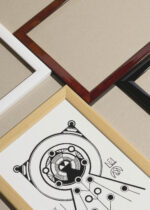 Widok z góry na cztery drewniane ramki, w jednej z nich oprawiony plakat mandala 1910 Samuel Mesquita czarno-biały geometryczny