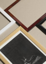 Widok z góry na cztery drewniane ramki, w jednej z nich oprawiony plakat antylopa drzeworyt de Mesquita czarno-biały vintage