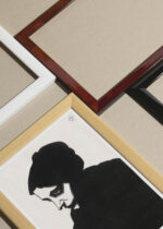 Widok z góry na cztery drewniane ramki, w jednej z nich oprawiony plakat czarno-biały portret kobiety 1913 Samuel Jessurun de Mesquita