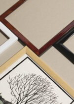 Widok z góry na cztery drewniane ramki, w jednej z nich oprawiony plakat drzewo nad wodą Julie de Graag drzeworyt 1919