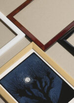 Widok z góry na cztery drewniane ramki, w jednej z nich oprawiony plakat Julie de Graag drzewo na tle księżyca niebieski vintage