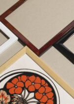 Widok z góry na cztery drewniane ramki, w jednej z nich oprawiony plakat kwiatowy Julie de Graag pelargonie vintage 1916