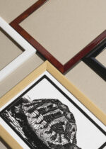 Widok z góry na cztery drewniane ramki, w jednej z nich oprawiony plakat żółw drzeworyt Julie de Graag czarno-biały