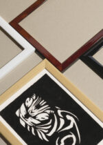 Widok z góry na cztery drewniane ramki, w jednej z nich oprawiony plakat śpiący kot Julie de Graag czarno-biały vintage