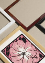 Widok z góry na cztery drewniane ramki, w jednej z nich oprawiony plakat kwiat Julie de Graag 1918 różowy vintage retro