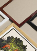 Widok z góry na cztery drewniane ramki, w jednej z nich oprawiony plakat kapusta i ślimaki Julie de Graag Art Nouveau vintage