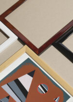 Widok z góry na cztery drewniane ramki, w jednej z nich oprawiony plakat abstrakcyjny geometryczny Wassily Kandinsky Gris 1931