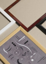 Widok z góry na cztery drewniane ramki, w jednej z nich oprawiony plakat Kandinsky Cztery Części abstrakcja geometryczna szara