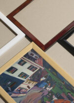 Widok z góry na cztery drewniane ramki, w jednej z nich oprawiony plakat Kandinsky Widok z okna Griesbräu ekspresjonistyczny widok miasteczka