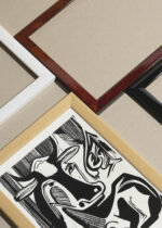 Widok z góry na cztery drewniane ramki, w jednej z nich oprawiony plakat Kirchner 1929 Wielka krowa odpoczywa czarno-biały ekspresjonizm