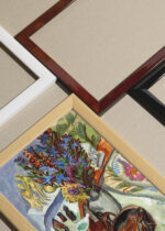 Widok z góry na cztery drewniane ramki, w jednej z nich oprawiony plakat Kirchner Martwa natura z dzbanem i afrykańską misą