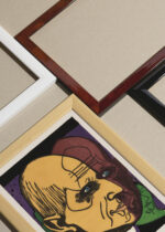 Widok z góry na cztery drewniane ramki, w jednej z nich oprawiony plakat Głowa Dr. Bauera (Kopf Dr. Bauer) Ernst Ludwig Kirchner