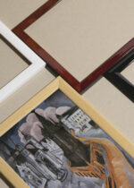 Widok z góry na cztery drewniane ramki, w jednej z nich oprawiony plakat Roter Turm w Halle 1915 Ernst Ludwig Kirchner