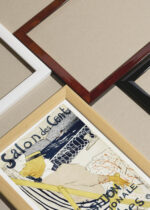 Widok z góry na cztery drewniane ramki, w jednej z nich oprawiony plakat Salon des Cent Toulouse-Lautrec kobieta na leżaku