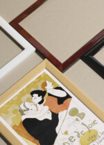 Widok z góry na cztery drewniane ramki, w jednej z nich oprawiony plakat Reine de Joie Henri de Toulouse-Lautrec 1892