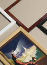 Widok z góry na cztery drewniane ramki, w jednej z nich oprawiony plakat Leonetto Cappiello kobieta z latarnią vintage