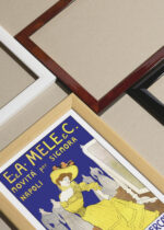 Widok z góry na cztery drewniane ramki, w jednej z nich oprawiony plakat Leonetto Cappiello żółta suknia moda vintage