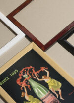 Widok z góry na cztery drewniane ramki, w jednej z nich oprawiony plakat Source Cachat Leonetto Cappiello art nouveau