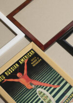 Widok z góry na cztery drewniane ramki, w jednej z nich oprawiony plakat Czerwony Diabełek Leonetto Cappiello 1906