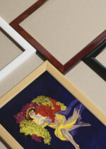 Widok z góry na cztery drewniane ramki, w jednej z nich oprawiony plakat Taniec winogron Leonetto Cappiello 1903