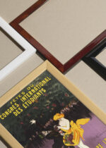 Widok z góry na cztery drewniane ramki, w jednej z nich oprawiony plakat Leonetto Cappiello tańcząca para Bordeaux 1907