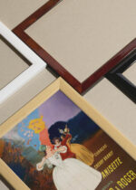 Widok z góry na cztery drewniane ramki, w jednej z nich oprawiony plakat Marie Brizard likier Leonetto Cappiello 1920