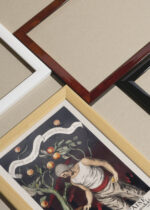 Widok z góry na cztery drewniane ramki, w jednej z nich oprawiony plakat Leonetto Cappiello mężczyzna z pomarańczami vintage