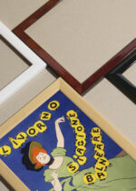 Widok z góry na cztery drewniane ramki, w jednej z nich oprawiony plakat Leonetto Cappiello 1901 festiwal Livorno Włochy