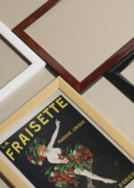 Widok z góry na cztery drewniane ramki, w jednej z nich oprawiony plakat La Fraisette Leonetto Cappiello likier vintage