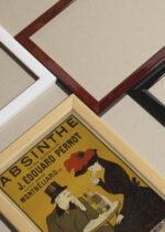 Widok z góry na cztery drewniane ramki, w jednej z nich oprawiony plakat Leonetto Cappiello absynt 1906 vintage Paryż